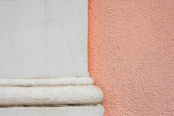 A white and pink wall with a white pillar standing against it.